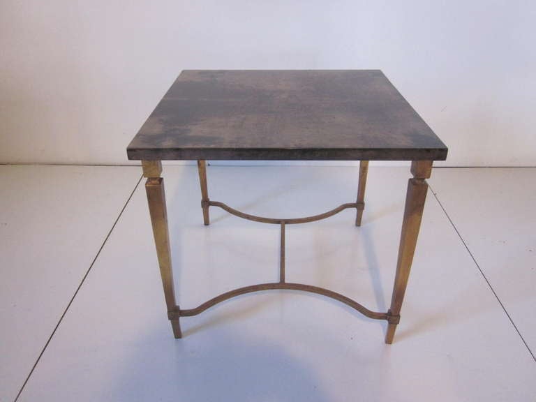 A rich mixed brown toned goat skin side table with elegant gold gilt metal base designed by craftsman and artist Aldo Tura.