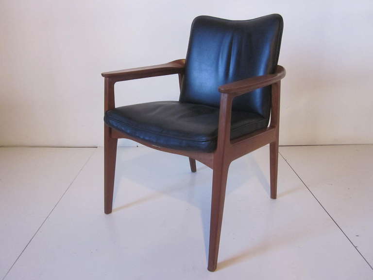 A rich black soft leather chair with sculptural teak wood frame with great detail, retains the designers brass signed tag,manufactured by France and Sons in Denmark.