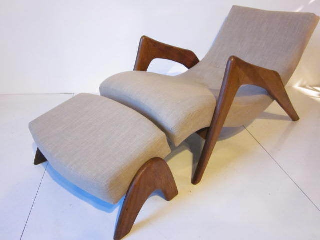 A  Pearsall Crescent lounge chair and matching ottoman with solid sculptural walnut arms and legs,upholstered in a fine linen fabric.Mfg.Craft Associates. A very rare and hard to find form.