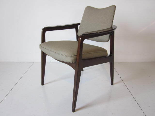 A Bernadotte dark wood armchair with tilt back and brass hardware imported by John Stuart company,retains all tags and designers signature tag.Mfg.by France & Daverkosen,Denmark