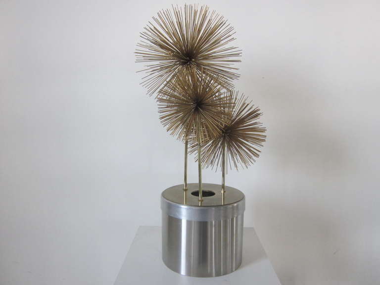 A large Jere Pom Pom sculpture with stainless and aluminum base that contains a up light for dramatic affect at night. The Pom Poms can be removed and placed in alternate spots to the top sleeves.