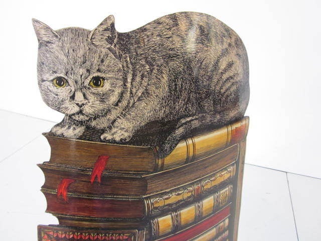A Fornasetti umbrella stand depicting a cat sitting on a pile of old books with a mouse to the lower bottom,retains the paper label to the verso made in Milano Italy.