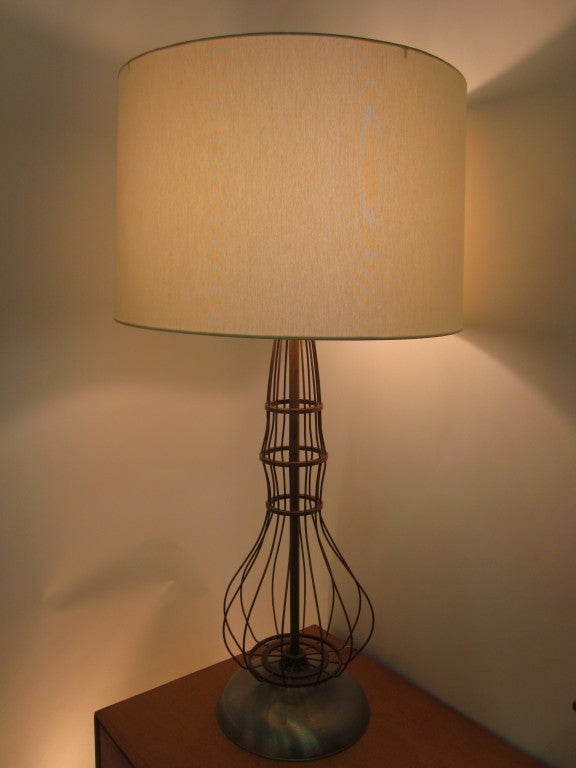 An industrial styled open shaped table lamp body made of brass ribs sitting on a heavy spun aluminum base topped by a wide rimmed linen shade. Marked on the bottom made by the Haws Drinking Fountain Co.Calif. A rare form . 