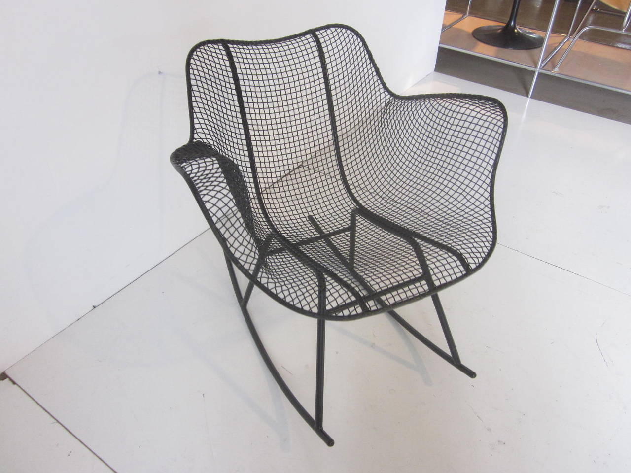 A molded steel mesh rocking chair in black wire and iron in the style of Charles Eames.