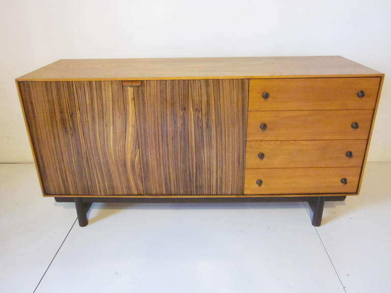 A fantastically wood grained Sever / Credenza with two zebra wood bi folding doors reveling ebonized pull out drawers and ABS molded plastic dish and glass holders. Four side drawers with bronzed colored pulls complete the storage all sitting on