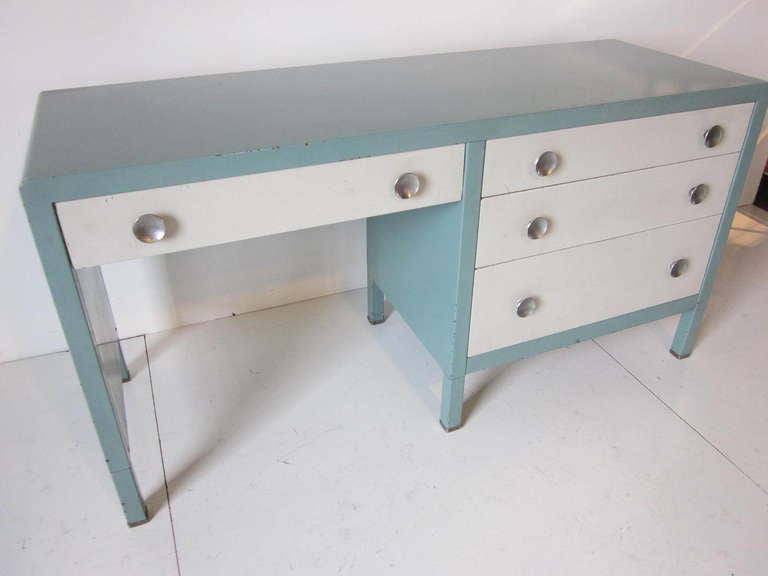 A Bel Geddes desk/ vanity in original painted steel with four drawers and round stainless steel pulls. Manufactured by The Simmons Furniture Company .