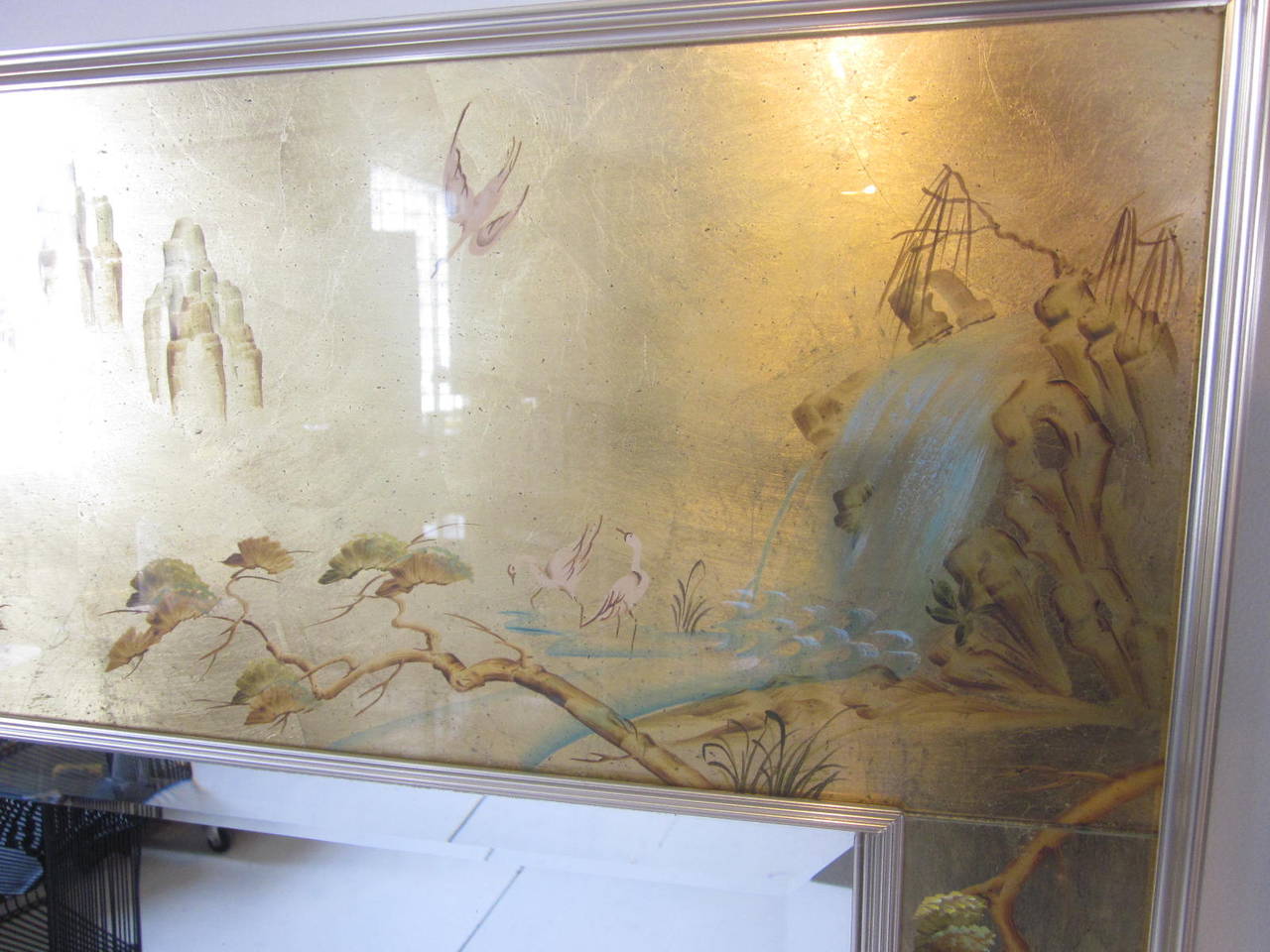 A gilt reverse painted églomisé mirror with Chinese motif, ribbed and fluted brass toned frame surrounding a beveled mirror. Manufactured to a high quality as always by La Barge signed and dated Jacobassc 1980.