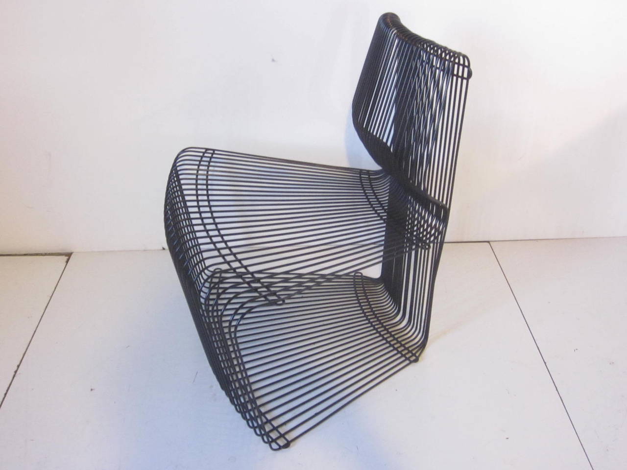 A black metal Pantonova wire lounge chair manufactured by Fritz Hansen.