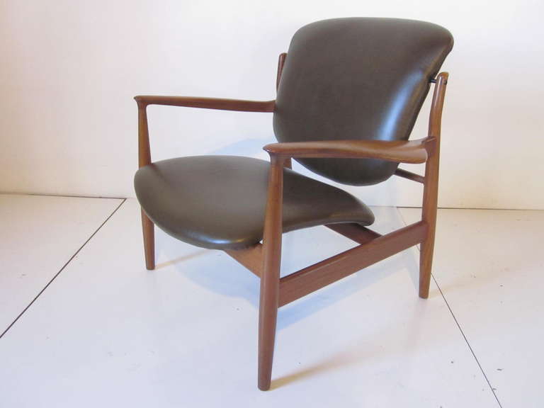 A sculptural and very well made important Finn Juhl Easy chair in teak wood with soft and supple green/ brown almost an olive leather. Wonderful details include fine joinery, enameled brass fittings and sexy curved arm rests,retains markings from