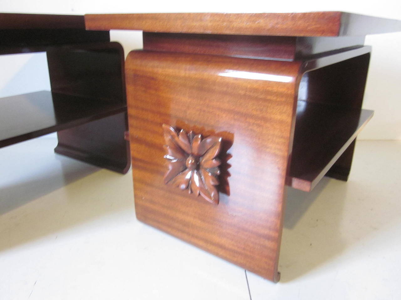 A pair of dark mahogany side tables with floating tops, carved flower designs to each end, lower shelve and a slight scroll leg to the base, a Classic look.