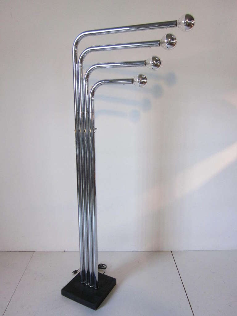A chrome Quad floor lamp with an angled top which each upper pole is movable left or right highlighting the chrome capped light bulbs, the switch located midway down the pole controls a 3 way switch for the two upper,two lower or all four bulbs on