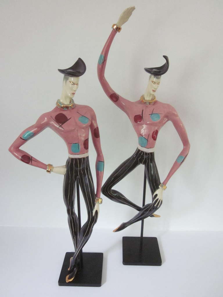 A pair of rare and hard to find Marc Bellaire Mardi Gras figures hand painted and signed by the artist they are supported or held aloft by heavy black metal stands. The figure on the left measures 24" and the one at the right rise to a