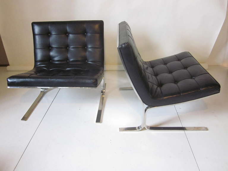 A pair of black leather lounge chairs in quality of the highest order ,mirror polished solid stainless steel and heavy black soft leather with individually welted panels and button tufting. Comfortable ,stylish ,tailored sitting on a cantilevered