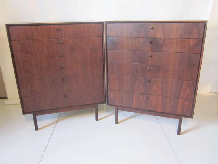 A matching pair of dark deep walnut tall chests with flamed grained fronts ,black button pulls ,clear wood interior drawers all sitting on square legs. These six drawer chests are just stunning together with the best wood grain we have seen which