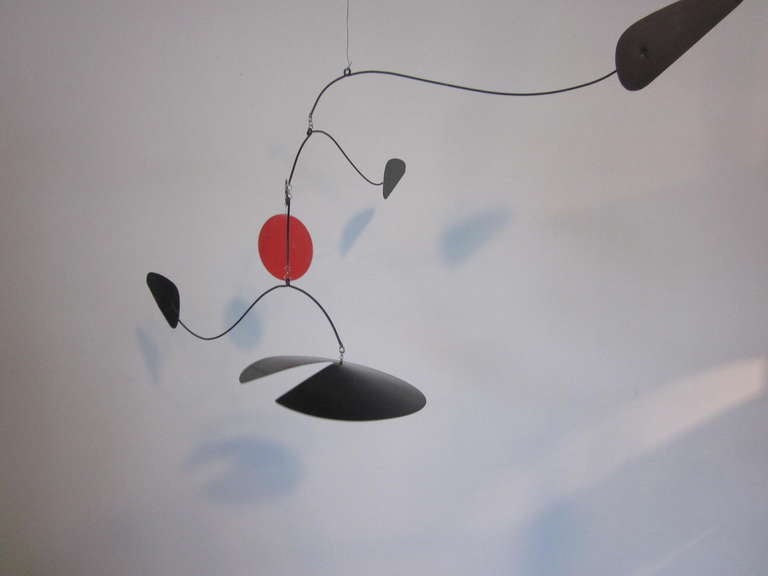 A hanging Mobile sculpture in the style of Alexander Calder consisting of satin black metal pieces accented by a large red dot. Signed on the end of one piece by the artist J.Hitchins . 