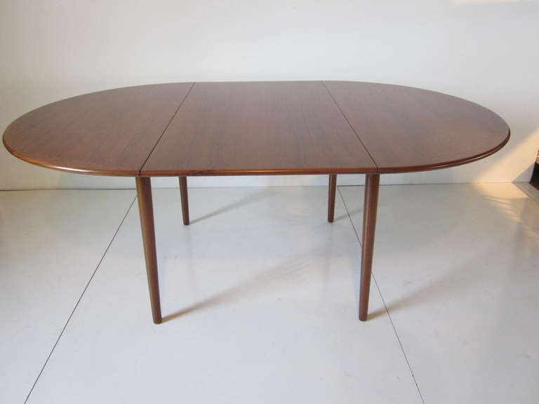 A dark teak wood Danish dining table with one 24.75