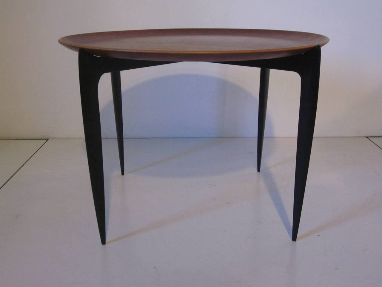A round dished teakwood tray tabletop with ebony black folding legs great for that small space, marked with stamp to both the top and legs, FH ( Fritz Hansen ) Made in Denmark.