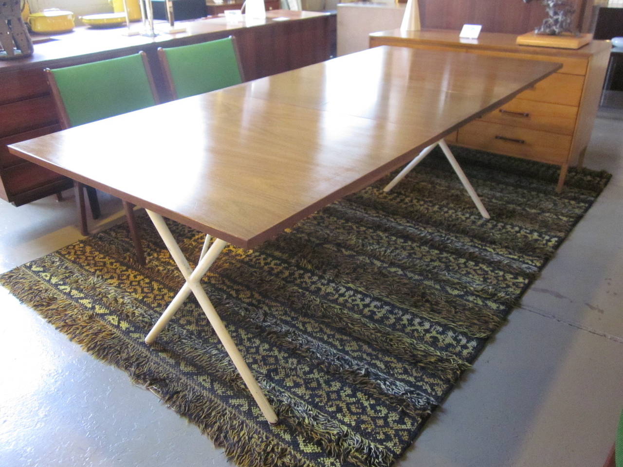 A special order walnut pop up leaf Nelson X-based dining table with satin white metal legs, book matched wood grains, one 18