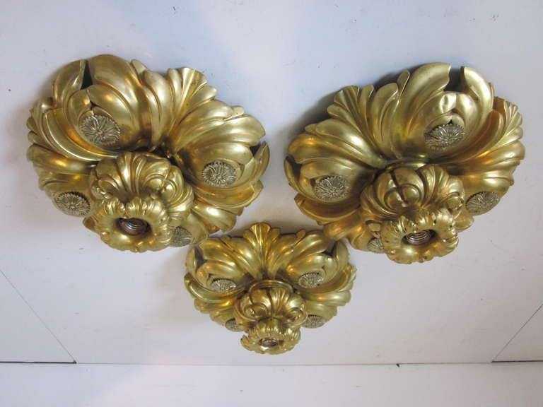 A lavish European styled gold gilded flush mounted ceiling light fixtures in the 1910's mix of Art Nouveau, Beaux Art and Deluxe high style design. Wonderfully detailed with rondials and leafy motif, and a single bulb fixture to the center filigree,