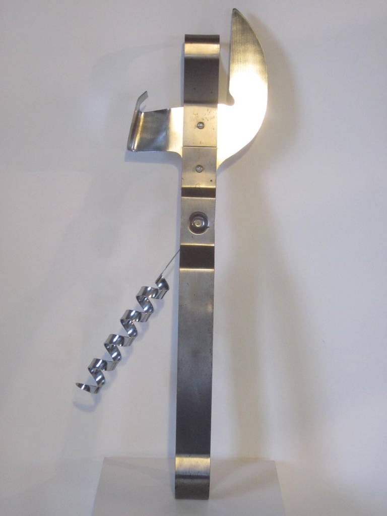 A biggie sized metal old style can, bottle and wine opener with fold out cork screw this wall sculpture was from the series of extra big kitchen items that were produced in the 1970s. Signed to the inside of the handle Curtis Jere 76, metal hooks to