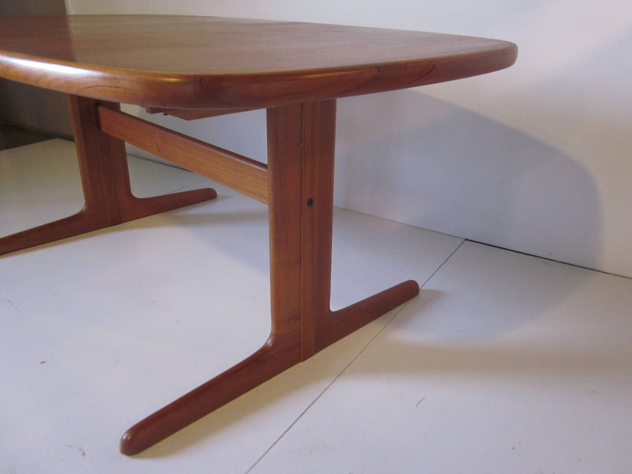 A teakwood dining table by Eric Buck with nice rounded edge. Two matching 19.63