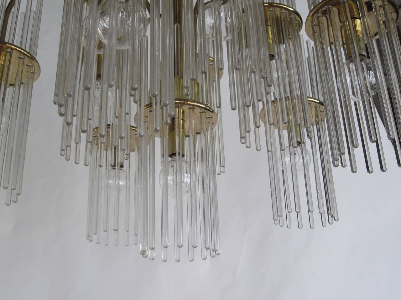 A Sciolari Italian chandelier with long crystal hanging rods mounted on brass fixtures with eleven-light clusters, these removable crystal rods defuse the light of each small bulb making the whole chandelier glow. The fixture itself is 21