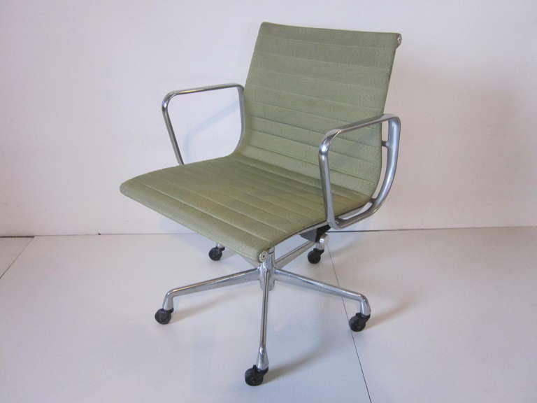 Eames Aluminum Group desk chair on a five star swiveling,rocking, rolling base with matching arms, in a sea foam green wool blended fabric. Manufactured by the Herman Miller Furniture Company.
