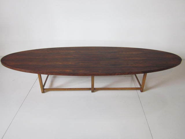 A brazilian rosewood surfboard coffee table with lighter wood legs,in exc.cond.Mfg.Lane Furniture Co.