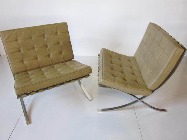A pair of Barcelona chairs with individual hand welted and tufted Sahara colored spinneybeck leather panels sitting on buffed stainless steel frames.Retains original tags,Mfg.Knoll International.