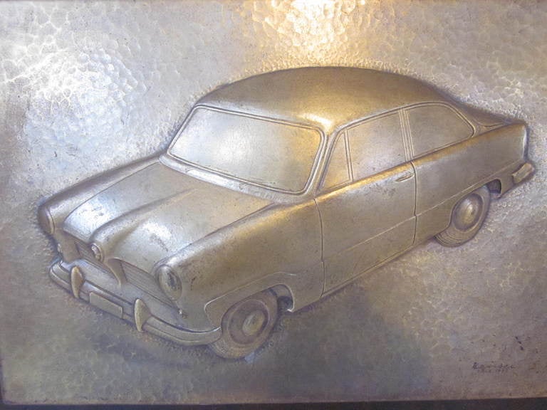 A bronze and dark wood German Ford presentation plaque with detailed relief of a 1952 Ford Taunus model with lower plaque signed by the design staff and wishing luck on the 30th anniversary of employment to one of the designers.To the lower edge