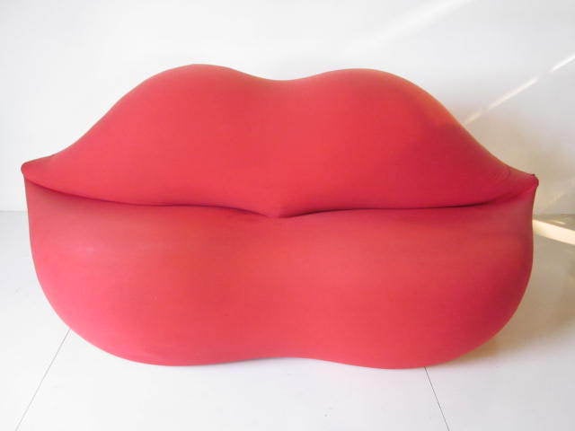 A vibrant lipstick red Marilyn Monroe Lip sofa in elasticated fabric on a metal frame done in a surrealistic style.Retains maker and importers tag-Italian Gufram Studio 65 Bocca By Stendig.