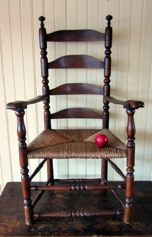 EXCELLENT EARLY FOUR SLAT LADDERBACK ARMCHAIR<br />
<br />
Rarely found C 1720 armchair, with great, tall, double reel finials, full sausage turned posts, vigorously turned double stretcher base, original rush seat, and well developed arms, with