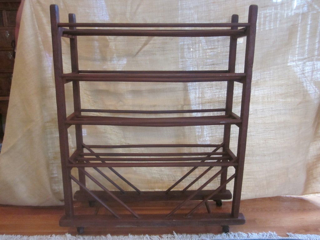 Antique wood cobblers rack on metal casters. Can be used in myriad ways:  Linen/towel storage, wine rack, wine glass rack, shoe storage...