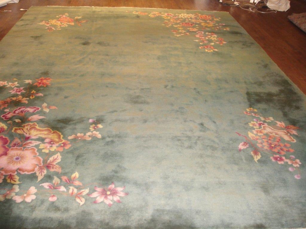 Beautifully crafted antique Chinese Art Deco wool rug.  Emerald green field  with coral, orange, ochre and mustard.