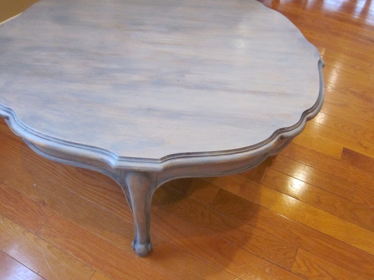 Large round wood coffee table with antique gray distressed (wax )finish.  Scalloped skirt with cabriole legs.