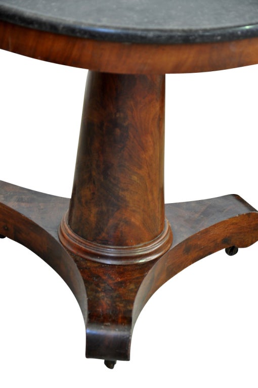 French antique Empire period round table/gueridon in mahogany. This piece has beautiful clean lines, an elegant design, warm patina, and the original marble top.This is the perfect foyer table but is also a good scale to be used as a end table or
