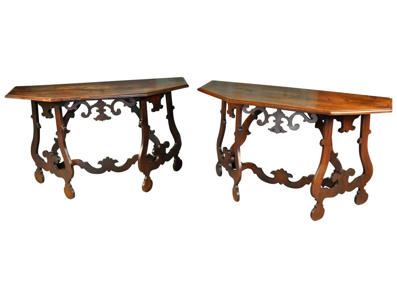 A pair of Northern Italian 19th century demilune consoles in walnut and mahogany.  Beautifully constructed with shaped trestle supports joined by a carved stretcher.