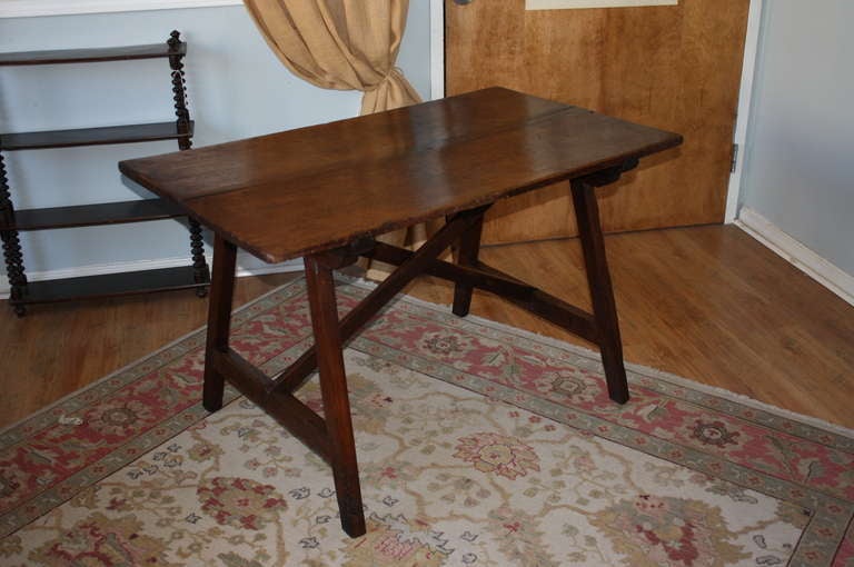 Antique Spanish trestle table in walnut from the late 18th century. This piece makes a perfect desk or writing table. It could also be used as a bedside table or end table. Pressed for space in an eat-in kitchen? This could make a great dining