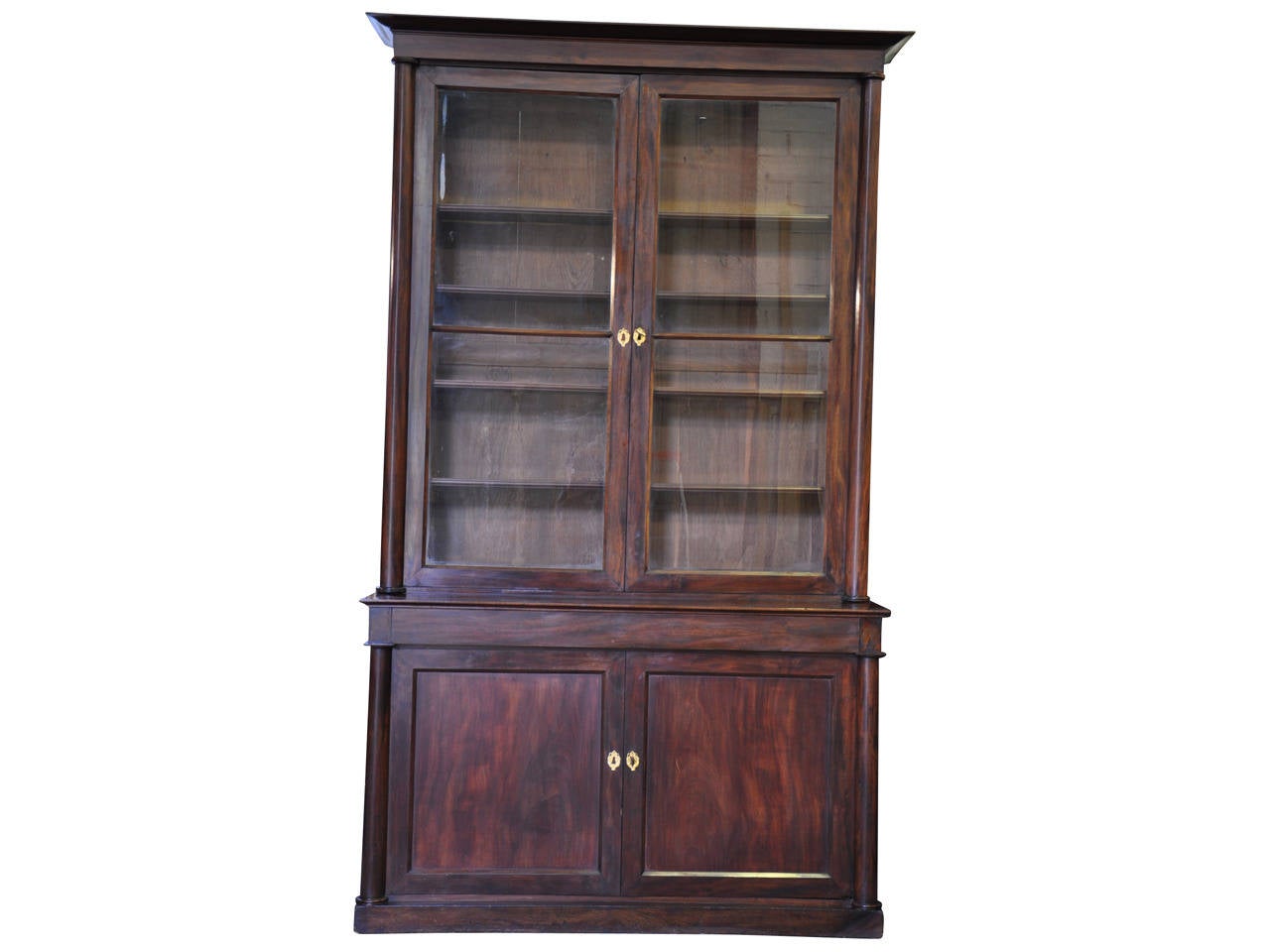 A stunning 19th century French Empire period bookcase constructed from mahogany. The large-scale and clean lines of this piece, along with the original wavy glass and wonderful grain patterns, indeed make this cabinet a true statement piece.