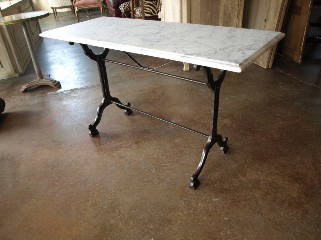 French Bistro Console Table with Cast Iron Base and Marble Top. This is would make a great dining table for a small eat in kitchen. It would also make a great console table for an foyer or a sofa table with a few lamps. The marble has beautiful grey