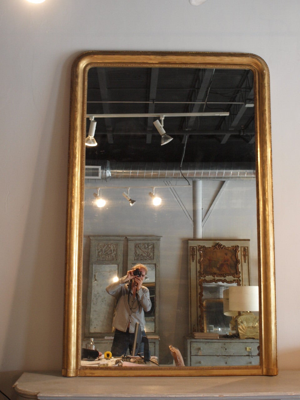Monumental period Louis Philippe mirror from France. This exceptional mirror is just shy of 7 feet. The mirror retains its original mercury glass mirror. The central convex section of the mirror features a lovely foliate pattern. The gilt work is