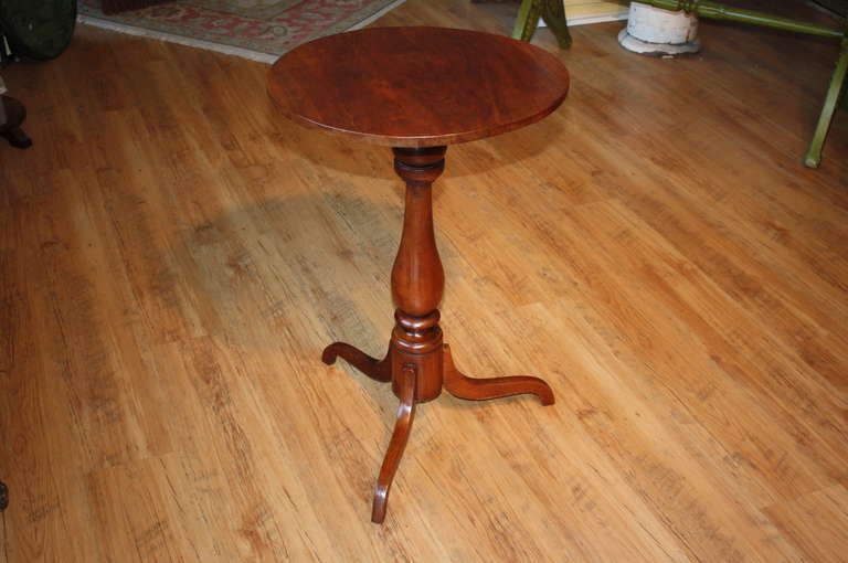 A charming English Tilt Top Candle Stand in Mahogany with baluster form shaft and three arched cabriole legs.  This piece has a lovely and warm patina with beautiful grain patterns.  It will be an excellent occasional table or bedside table.