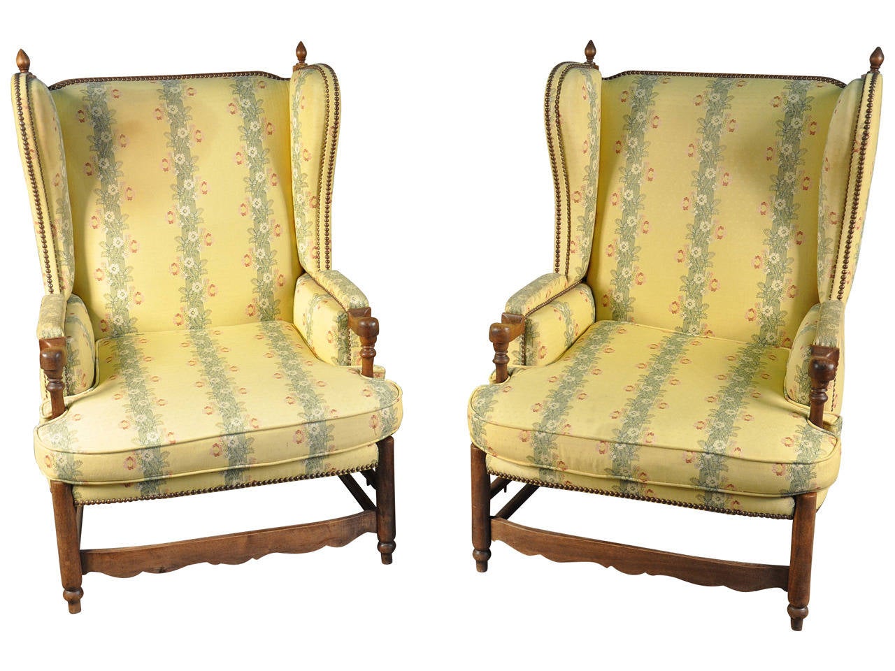 A charming pair of French Provencal armchairs in walnut.  These wingbacked armchairs are beautifully constructed with ladder backs and sculpted stretchers.