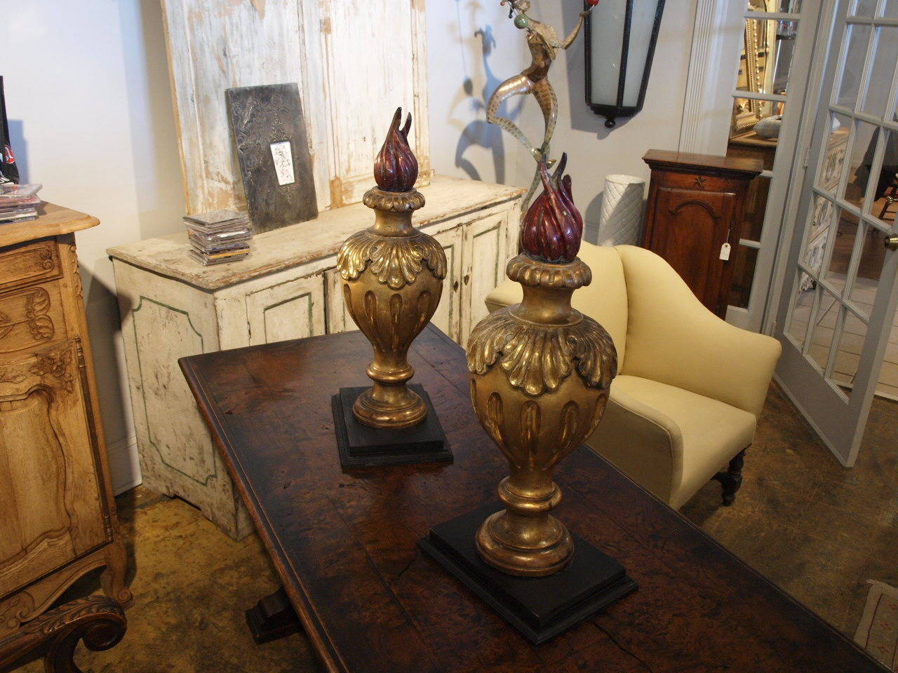 A stunning pair of 19th century Italian flame finials in giltwood. The finials rest upon their removable - added bases. Exquisite decorative objects as they are, or converted into lamps. The overall dimension with the finial standing in its base is