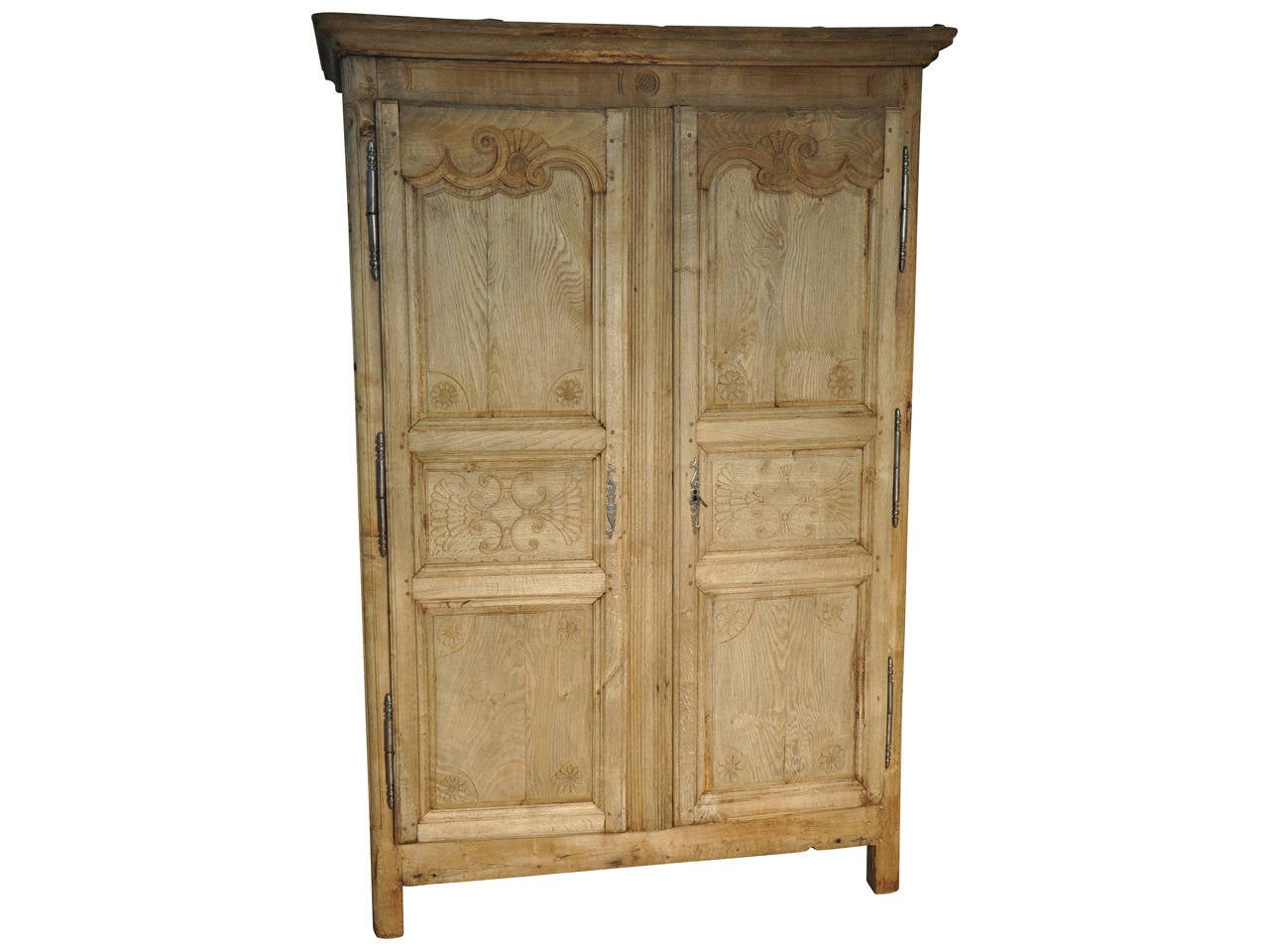 A very handsome 18th century Louis XIV style armoire in bleached oak from the South of France.  This delightful armoire has charming carving detail to the door panels.  It is an excellent storage piece and also wonderful to outfit as a bar or