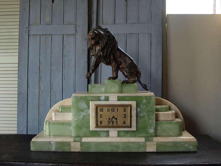 Monumental Art Deco Clock in green onyx and marble with spelter figure of lion resting upon the top. This is a beautiful piece and would make an impressive clock to grace the top of a large mantel.

Keywords: mantel clock, decorative objects,