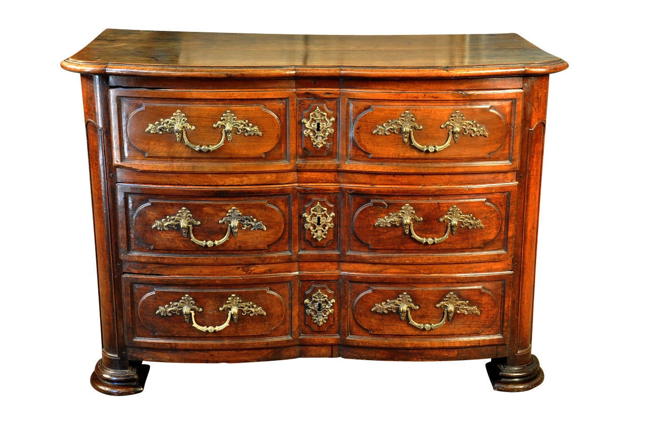 An outstanding French Louis XIV style commode constructed from solid walnut. This exceedingly handsome commode retains its original hardware. The graceful lines of this commode reflect the piece's elegance and style. The commode has a luxurious