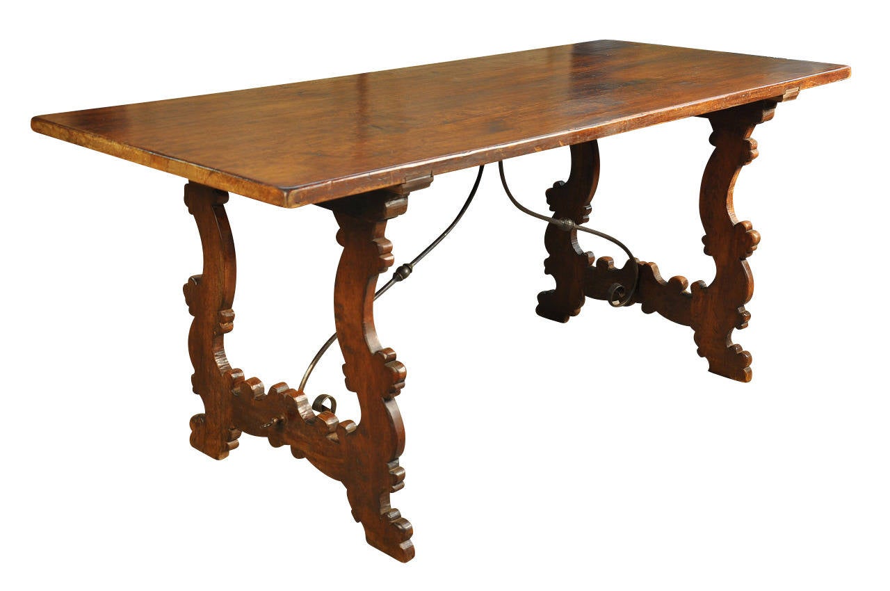 A very handsome Italian farm table or trestle table in walnut.  Beautifully constructed with hand wrought iron stretchers.  The patina is very rich and luminous with beautiful grain patterns.  Wonderful not only as a dining table, but would serve