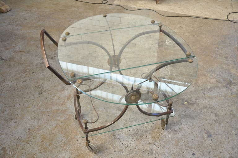 French early 20th century tea / bar cart in glass and brass. This piece can be used with the two glass drop leaves expanded to make a cocktail table or with the sides down to use as a bar cart.

Keywords: cocktail table, accent table, tea cart,