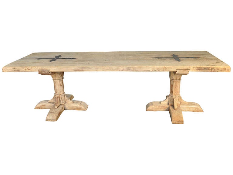 A striking 19th century washed oak monastery table from France.  The thick top is beautifully decorated with two iron crosses.  The handsome pedestal feet make this table a true statement.